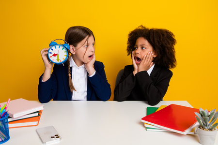 Two cheerful school-aged girls expressing surprise while holding colorful props, set against a...