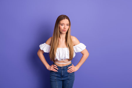 Stylish young woman in casual outfit making expressions against a violet background, showcasing...