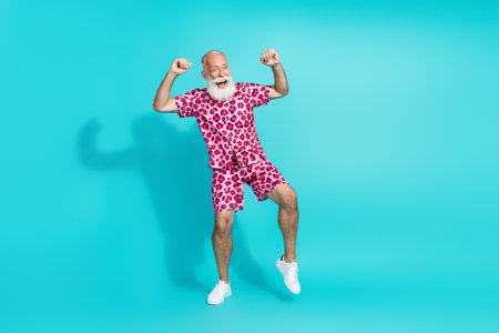 Full size photo of funny aged man rejoice dance wear leopard print outfit isolated on teal color backgroundの写真素材