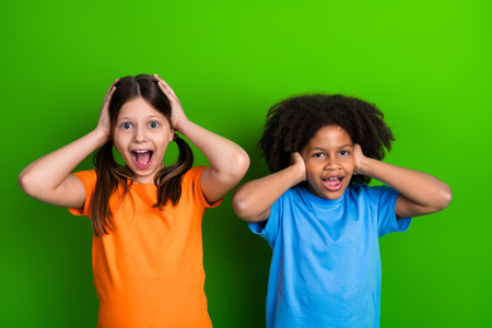 Portrait of cheerful diverse girls in colorful outfits gesturing on a vibrant green backgroundの写真素材