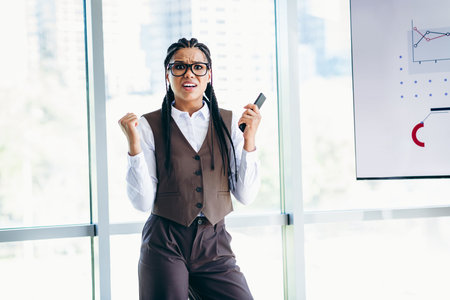 Confident businesswoman delivering a dynamic presentation during a corporate meeting in a modern office settingの写真素材