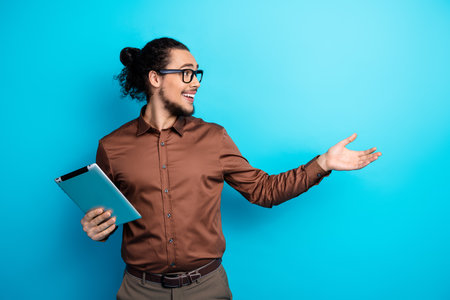 Trendy young man in a brown shirt showcasing a bright idea with expressive gestures on a vibrant...