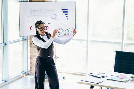 Confident businesswoman delivering a dynamic presentation while showcasing strategic insights in a modern corporate officeの写真素材