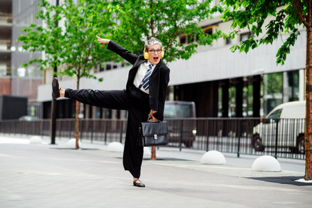 Excited businesswoman expresses joy outdoors in a city setting with vibrant energy and style showcasing professional attireの写真素材