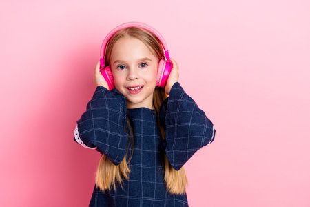 Smiling young girl headphones on pink background - vibrant and happy music lifestyle conceptの写真素材