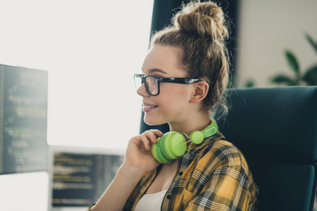 Skilled Young female programmer coding in a casual workspace with a laptopの写真素材