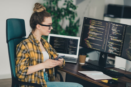 Young Woman in a Casual Workspace Working on Software Development by Demonstrating Her Professional...