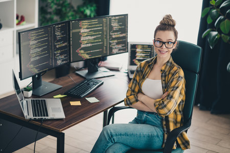 Young Female Programmer in Casual Attire Working Remotely at Home View of Her Setup and Screensの写真素材