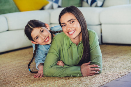 Mother and daughter enjoying time together indoors, showcasing family love and joyful bonding at home on a relaxed dayの写真素材