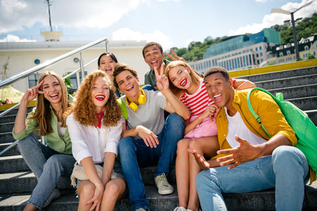 Students outdoors in the city on a sunny day, enjoying a shared moment of laughter, fun, and...