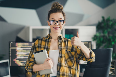 Young professional female programmer smiling confidently in a modern home office with technology and creativityの写真素材