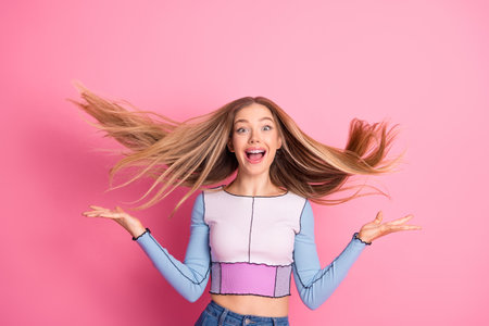 Radiant young woman with vibrant expression and stylish fashion against pink background showcasing...
