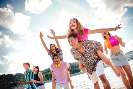 Joyful group of friends enjoying a summer day by the water showcasing laughter and youth