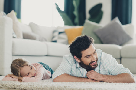 Father enjoying quality time with his daughter on a cozy day indoors, promoting family bonding and parental loveの写真素材