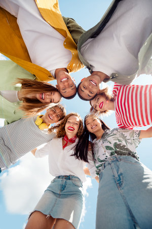 Multicultural group young best friends enjoying a sunny day outdoors, embracing friendship and happiness in a cheerful gatheringの写真素材