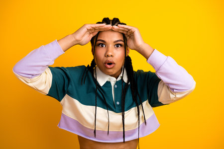 Young stylish woman in casual outfit displaying excited expression with hands after discovering a...