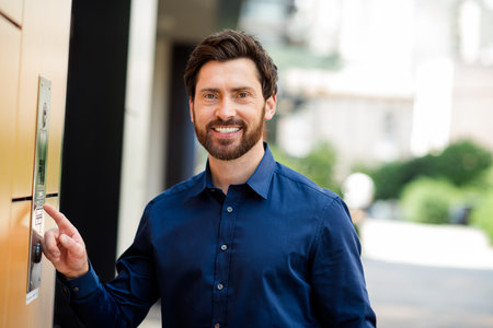 Smiling businessman at the office intercom outdoors, stylish professional embracing urban lifestyle...