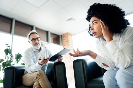 Professional dialogue between colleagues in a modern workspace with diverse perspectives and...