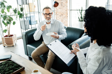 Professional man having a discussion with a coworker in a modern office environment, showcasing...