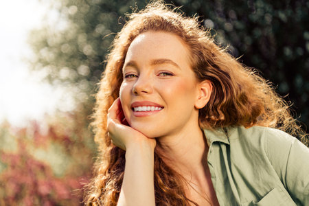 Young woman enjoying sunny day outdoors with a radiant smile and natural beauty