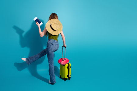 Young Female Traveler with Suitcase and Hat Enjoying Leisure Vibrant Backgroundの写真素材