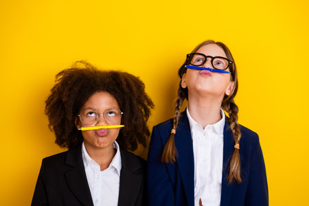 Playful Friends With Funny Poses Holding Pens on Yellow Background in Uniforms