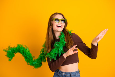 Energetic woman having fun dancing in vibrant outfit with yellow background, showcasing lively and...