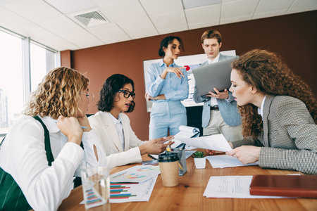Diverse group of professionals collaborating in an office, discussing a business project with teamwork and cooperationの写真素材