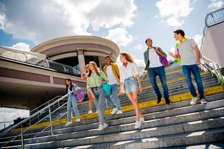 Youthful friends enjoy a lively walk together on urban outdoor stairs on a beautiful sunny day