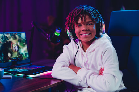 Energetic teenager enjoying online gaming and vlogging at home under vibrant neon lightingの写真素材