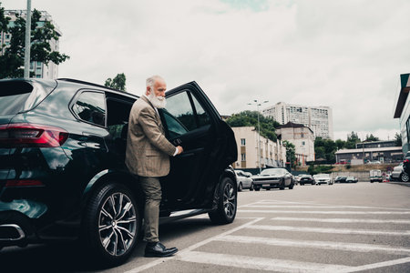 Confident mature businessman exiting the car in an urban area showcasing style and elegance