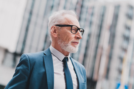 Handsome man businessman outdoors in urban environment wearing formal suit showcasing professionalism and determinationの写真素材