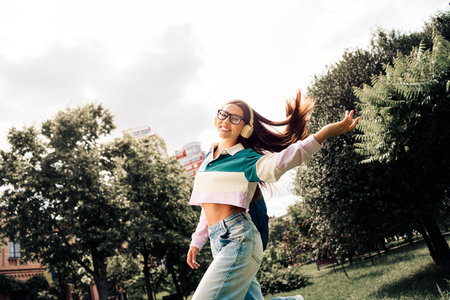 Joyful young woman enjoying a day outdoors in a trendy outfit, showcasing style and happiness in an...