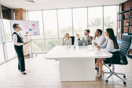 Professional team collaborating in a modern office setting during a presentation, fostering...