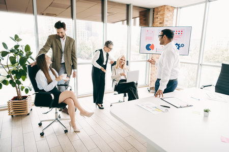 Diverse team collaborating in a modern office space with technology displays and discussing project...