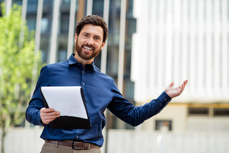 Young confident businessman presenting ideas outdoors in an urban setting during springtimeの写真素材