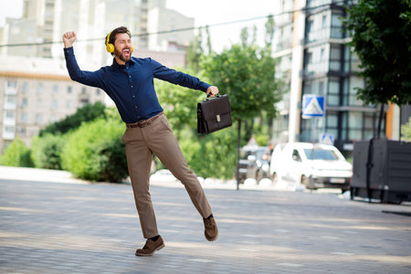 Young vibrant professional celebrating success outdoors in a dynamic urban setting showcasing energy and determinationの写真素材