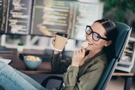 Charming Female IT Professional Relaxing While Working Remotely from Home on Programming Projects in...