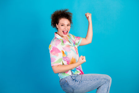 Confident young woman in colorful casual outfit showing strength with a cheerful expression against...