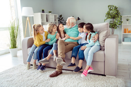 Full size photo of young positive lovely children sit sofa with old man in glasses grandfather...