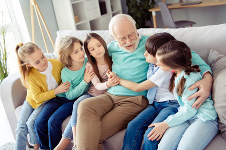Photo of happy positive good mood family grandfather in glasses talking speaking with his...