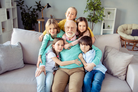 Photo of happy positive smiling good mood family grandfather babysitting little children hug embrace...
