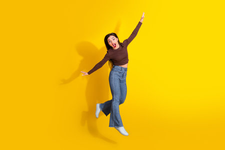 Charming woman in casual attire on vibrant yellow background showcases a joyful expression with...