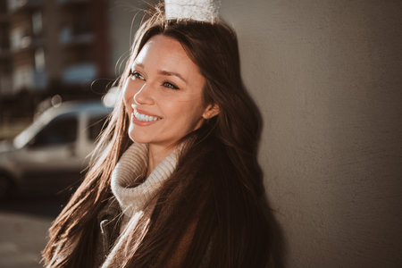 Outdoor portrait of a charming young woman enjoying a sunny day surrounded by urban scenery