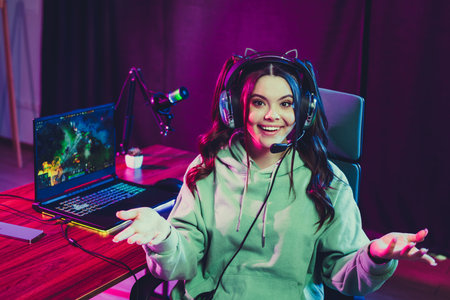 Young female gamer excitedly streaming online gameplay from her neon-lit home setup with gaming...