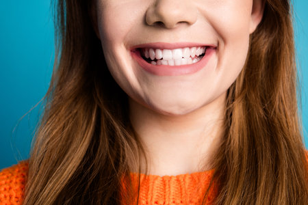 Close-up of a young womans joyful smile with vibrant colors highlighting her happiness and cheerful...