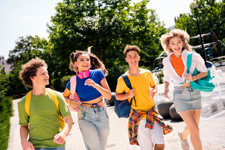 Group of happy young friends walking together outdoors spending leisure time with fun and joy on a...