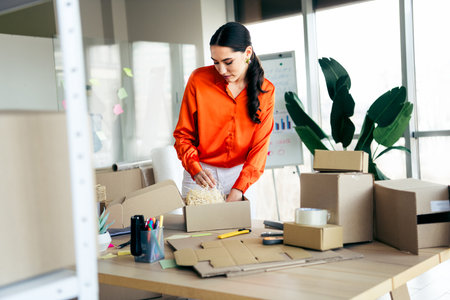 Starting a small business entrepreneur preparing packages in modern office workspace