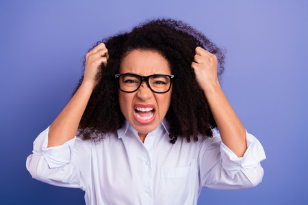Energetic young woman in formal attire expressing strong emotion on a vibrant purple background