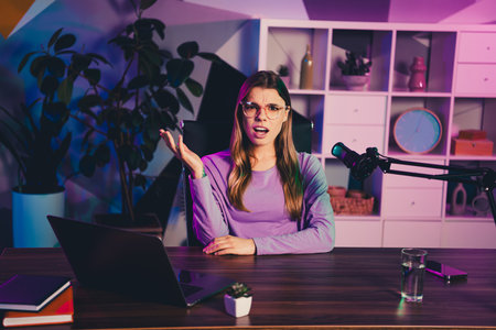 Popular blogger recording content in a modern studio with neon lighting setup and professional mic...